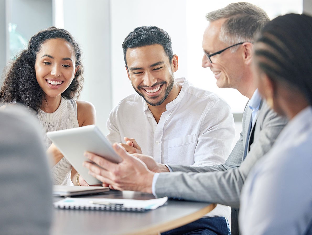 Três pessoas sorridentes a olhar para um bloco
