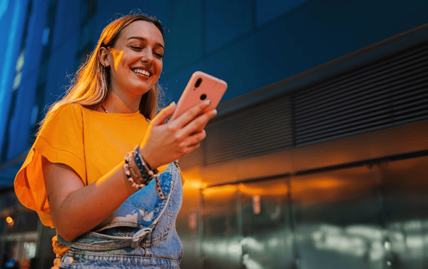 menina-na-rua-com-telemovel-na-mao-desktop