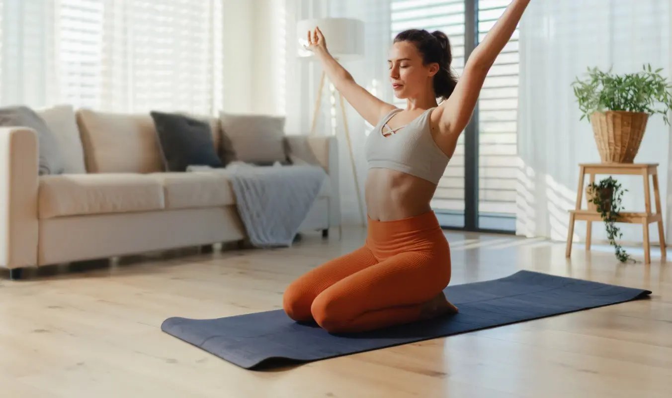 senhora-a-fazer-exercicio-num-tapete-yoga-na-sala-desktop