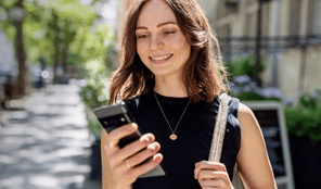 senhora-a-sorrir-na-rua-a-mexer-telemovel