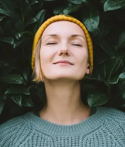 senhora-de-olhos-fechados-tranquila-com-gorro-amarelo