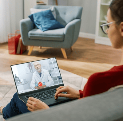 senhora-no-sofa-com-computador-no-colo-a-ter-video-consulta-mobile
