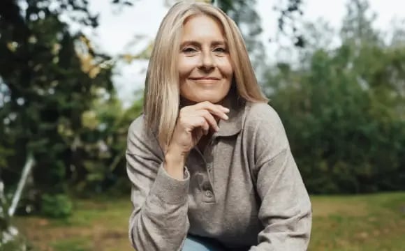 senhora-sentada-a-sorrir-num-jardim-desktop