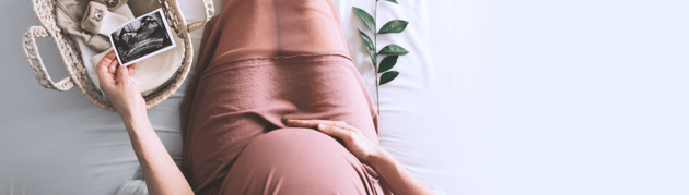 Grávida a tocar com a mão na barriga