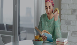 menina-a-comer-uma-maca-e-a-ler-nutricao-oncologica-thumbnail