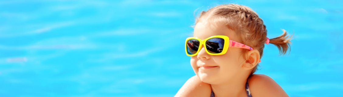 Criança na piscina com óculos de sol