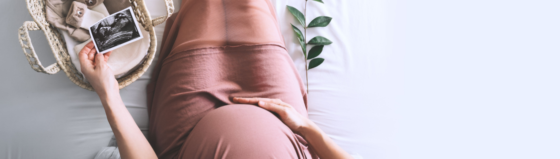 Grávida a tocar com a mão na barriga