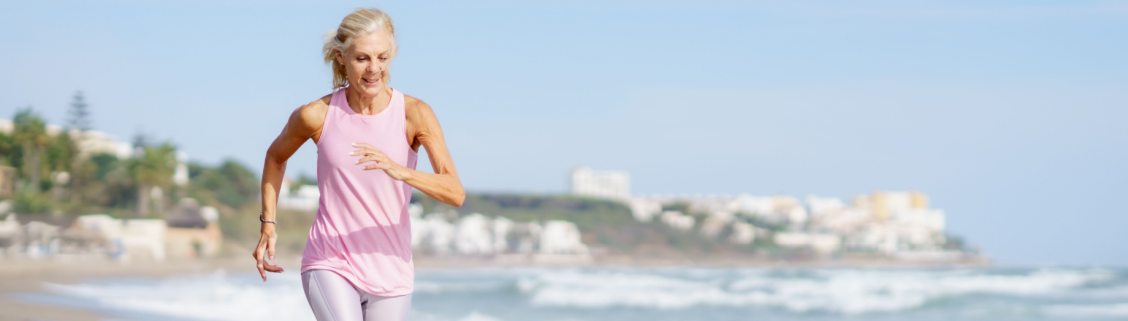 Mulher 65+ a correr na praia
